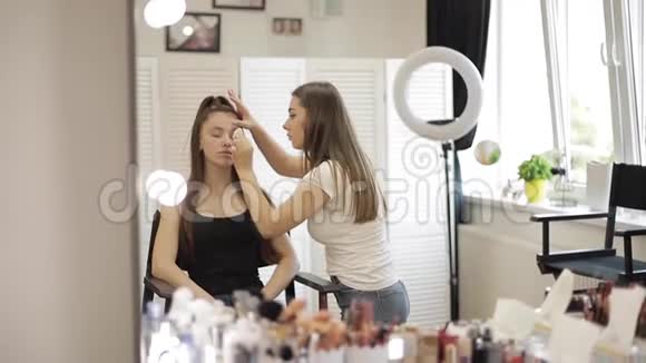 化妆师在美容工作室和模特一起工作时尚为优雅的红头模特而不化妆开始视频的预览图