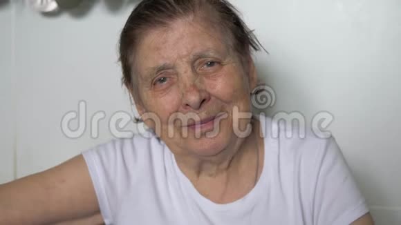 一位满脸皱纹看镜头笑的老妇人的画像视频的预览图