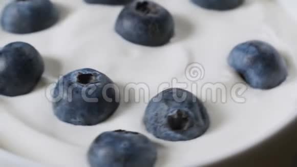 有机酸奶中的蓝莓旋转循环视频4k镜头视频的预览图