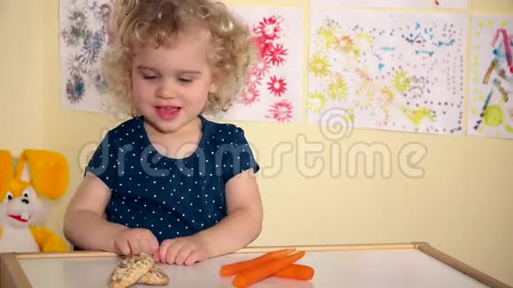可爱的小女孩选择吃胡萝卜而不是蜂蜜蛋糕视频的预览图