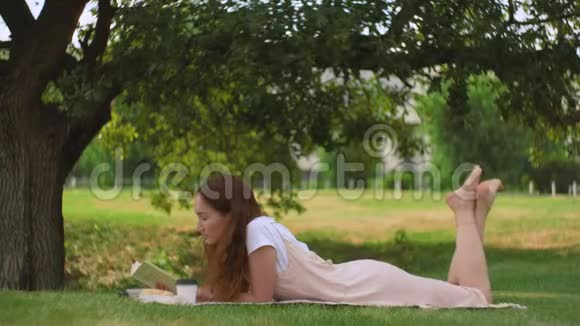 年轻女子躺在树下看书视频的预览图