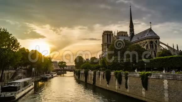 日落时分巴黎的时光流逝船在塞纳河畔巴黎圣母院教堂前经过视频的预览图