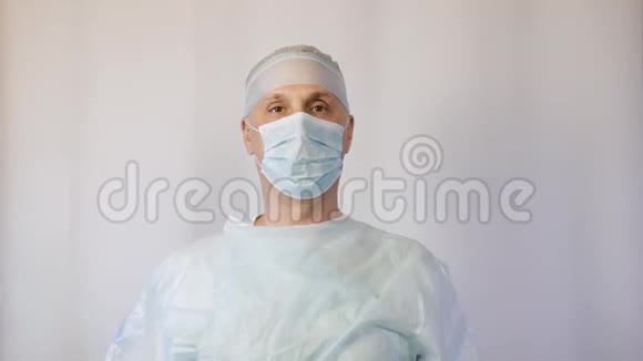 医生是一位戴着医用口罩的外科医生向病人展示一切都很好他抬起拇指视频的预览图