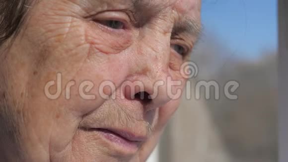 一位因颤抖的眼睑而痛苦的老妇人悲伤的面容特写视频的预览图