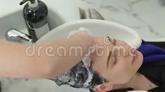 女性程序头发长长的黑发女孩去美容院洗头视频的预览图