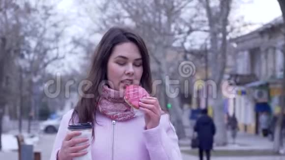 糖果诱惑漂亮的女孩吃着的饼干喝塑料杯里的茶视频的预览图