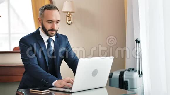 自信成功的男性商人用笔记本电脑打字或键盘聊天视频的预览图