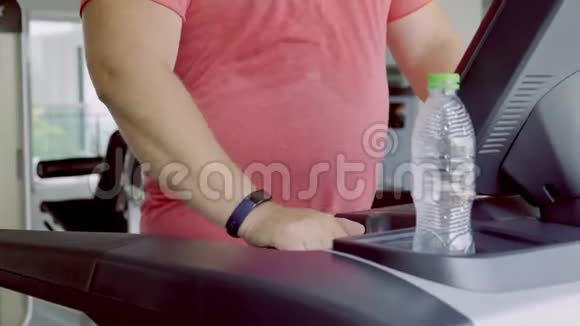 全男在健身房的跑步机上跑步减肥和运动的概念特写视频的预览图