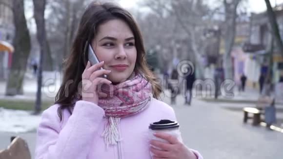 一幅美丽的女人在城市里走来走去用手机说话视频的预览图