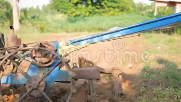 老人用小拖拉机耕田调整土壤进行种植视频的预览图