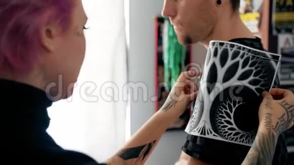纹身师试着在客户肩膀上素描视频的预览图
