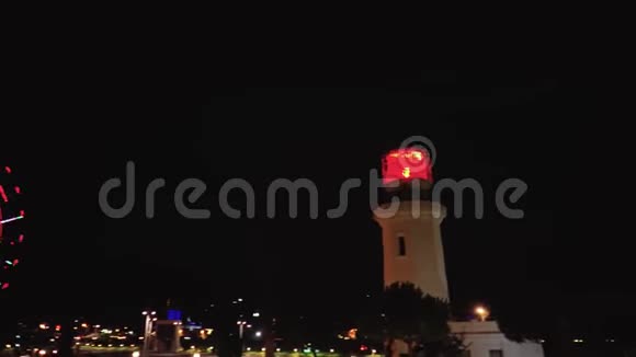 带有棕榈树和摩天轮的灯塔的公园夜景视频的预览图