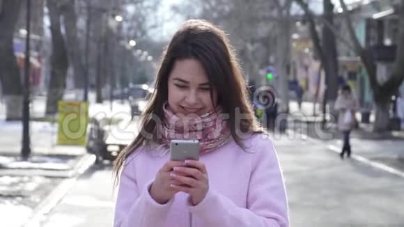 社交网络笑的女人用手机在网络上和街上的朋友交流视频的预览图