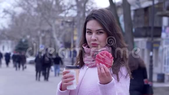 在城市特写镜头中饥饿的女人在露天的塑料杯里夹着饼干和茶视频的预览图