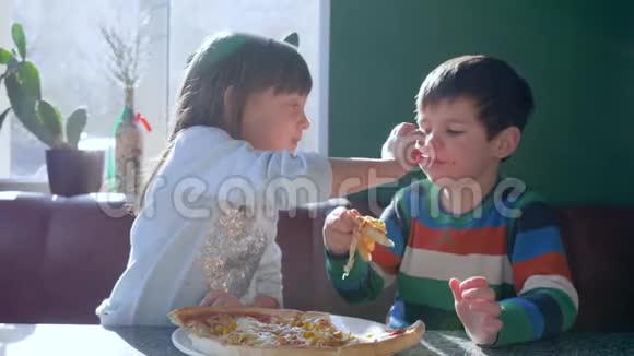 吃饭时间带披萨的小女孩在靠近窗户的餐厅吃饭视频的预览图