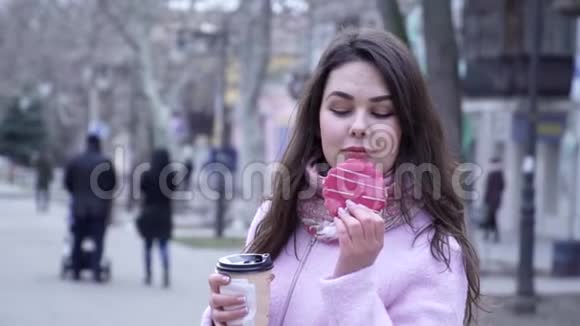 美食诱惑饥饿的女性在街上拿着饼干和塑料玻璃咖啡视频的预览图