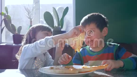 家庭午餐肮脏的孩子在靠近窗户的比萨饼店吃开胃菜视频的预览图