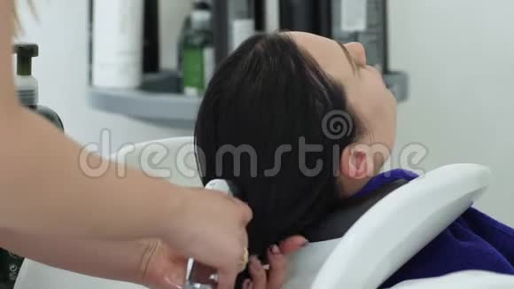 个人卫生在美容院洗头的长发女孩视频的预览图