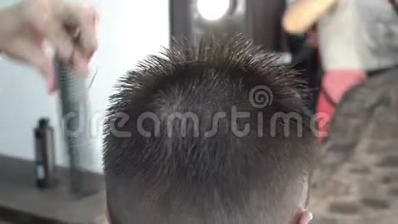 理发师在理发师给一个男人剪短发把她的头发剪在剪头的背面视频的预览图
