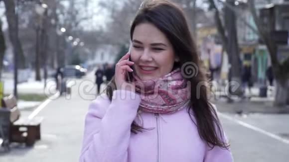 电话交谈快乐的女人在街上散步时在手机上交谈视频的预览图