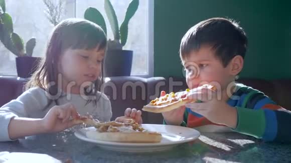孩子们的快乐饥饿的孩子们在自然采光的比萨饼店吃快餐视频的预览图