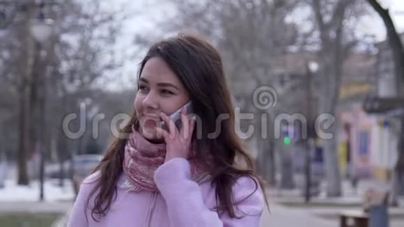 移动通讯欢快的女孩在街头特写镜头上通过手机交谈视频的预览图