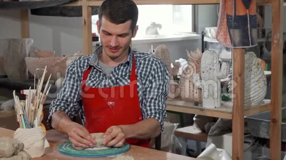 年轻的男性陶瓷艺术家在工作时微笑着对着镜头视频的预览图
