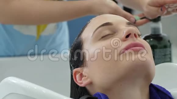 美容美发中心理发师用专业洗发头洗美容美发中心的快乐顾客视频的预览图