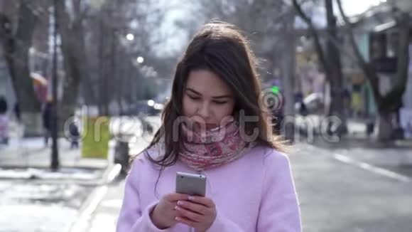 手机成瘾漂亮的女孩用智能手机在露天社交网络交流视频的预览图