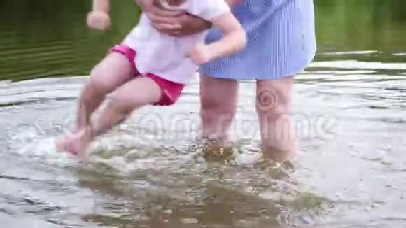 小女孩的母亲在河里洗脚女人在沙滩上玩她的孩子视频的预览图
