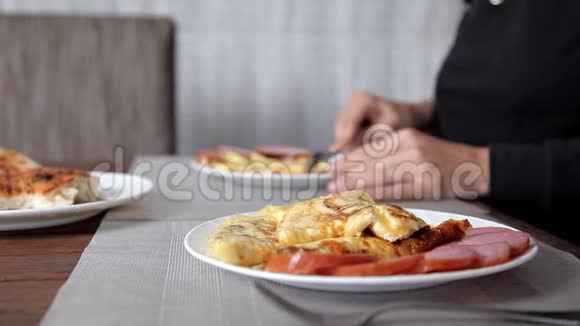 家庭早餐男人和女人吃早餐吃煎蛋卷和肉视频的预览图