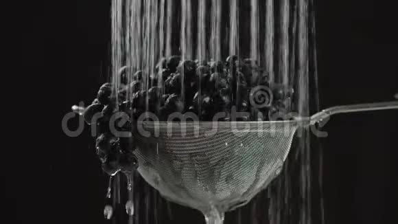 在视频中我们看到葡萄在筛子中水从视频的末端从顶部落下水停止了黑色的背景视频的预览图