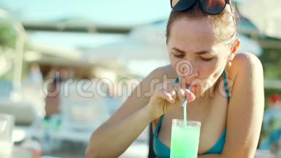 泳池酒吧的一位女士正在喝一杯鸡尾酒视频的预览图