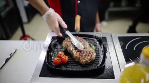 在厨房工作的厨师在锅里做一份煎牛排视频的预览图