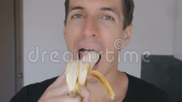 在家厨房里吃香蕉的年轻人视频的预览图