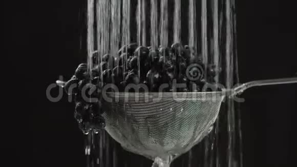 在视频中我们看到葡萄在筛子中水从顶部落下来在单个喷射然后停止黑色的背景视频的预览图