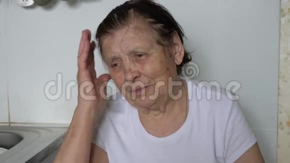 一个老妇人把她的头递给她她有一个头痛视频的预览图
