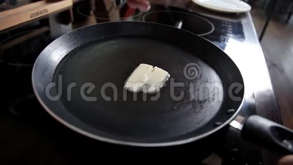 女孩把黄油涂在红火锅上烹饪早餐视频的预览图