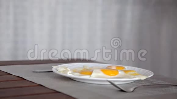 一个年轻的女孩为早餐准备了炒鸡蛋放在桌子上还有一杯牛奶视频的预览图