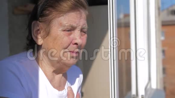 一位老年妇女从窗户往外看视频的预览图