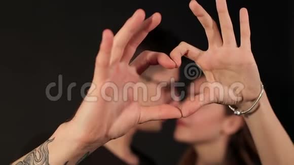 漂亮的年轻夫妇正在做手指的心脏视频的预览图