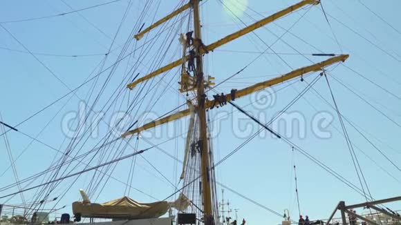 水手们在4k港的一艘漂亮的帆船上爬下一根火柴视频的预览图