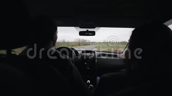 年轻的夫妻坐汽车沿着乡村公路旅行后视图视频的预览图
