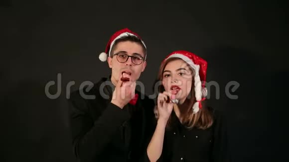一对戴圣诞帽的夫妇在派对上戴节日喇叭视频的预览图