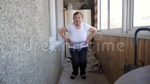活跃的老年妇女在阳台上做早操视频的预览图