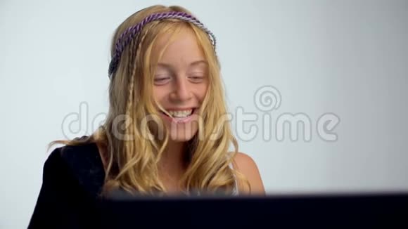 一个微笑的年轻女子用笔记本电脑的画像视频的预览图