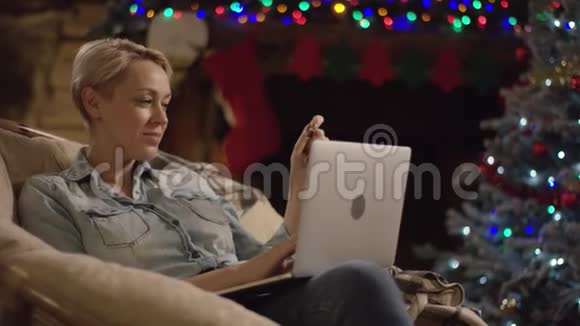 短头发的女人在圣诞夜使用笔记本电脑和信用卡在网上购物视频的预览图