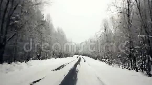 驱车穿越冬林雪道初观在stealicam的窗户外的摄像头冬季农村公路视频的预览图