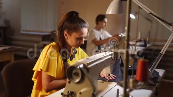 裁缝师在餐桌上的裁缝工作室里做缝纫机时装女裁缝的专业职业视频的预览图