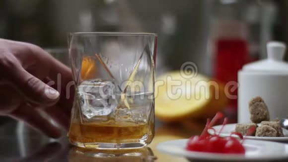 把糖放进去酒保在现代酒吧准备鸡尾酒巴门搅拌浇筑橙汁的甜味视频的预览图